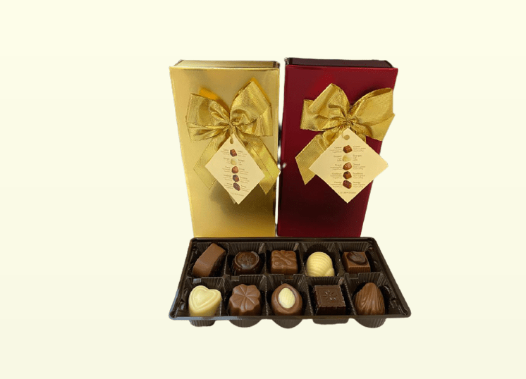 שלוש קופסאות שוקולד בלגי, אחת פתוחה. השוקולד הוא מריר, חלב ולבן בצורות שונות