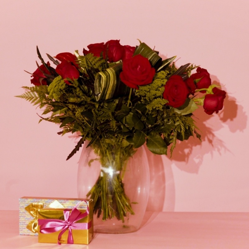 זר ורדים בתוך אגרטל זכוכית ושוקולדים