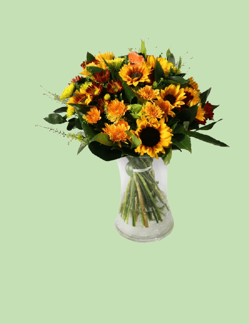 זר חמניות ועוד פרחים צהובים וכתומים בתוך אגרטל זכוכית
